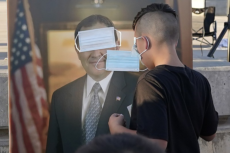  In this Saturday, Sept. 5, 2020 file photo, children play "pin the mask on Gov. Gary Herbert" during a "Trash Your Mask Protest" rally hosted by the Utah Business Revival at the Utah State Capitol in Salt Lake City. The event was held to protest Herbert's order requiring all K-12 schools in Utah to require face coverings to stop the spread of the coronavirus. According to a study by health officials in Utah and at the Centers for Disease Control and Preventionn released on Friday, Sept. 11, 2020, children in the state who caught coronavirus at day care programs or day camps spread it to about 25% of the people they encountered later, highlighting the role children can play a role in spreading the virus from child care settings to household contacts. (AP Photo/Rick Bowmer)