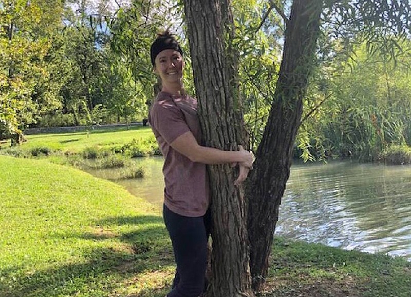 Contributed photo / Adrienne Long hugs a tree at Heritage Park in East Brainerd. On Sept. 19, she plans to hug the same tree for at least 10 hours in an attempt to break the record for the world's longest tree hug.