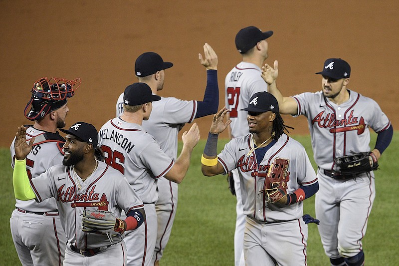 Atlanta Braves' Marcell Ozuna, front left, Ronald Acuna Jr., front center, Adam Duvall, front right, and others celebrate after a baseball game against the Washington Nationals, Saturday, Sept. 12, 2020, in Washington. (AP Photo/Nick Wass)