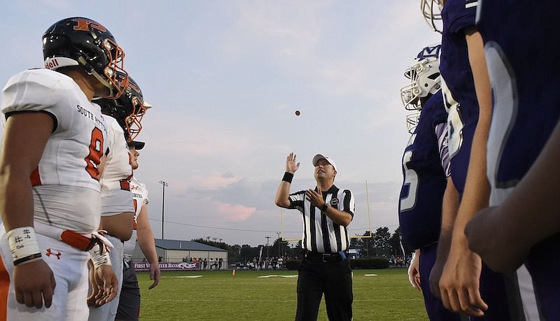 Staff Photo by Robin Rudd / The referee tosses the coins while the captains look on. The South Pittsburg Pirates visited the Marion County Warriors in a TSSAA rivalry game on September 13, 2019.