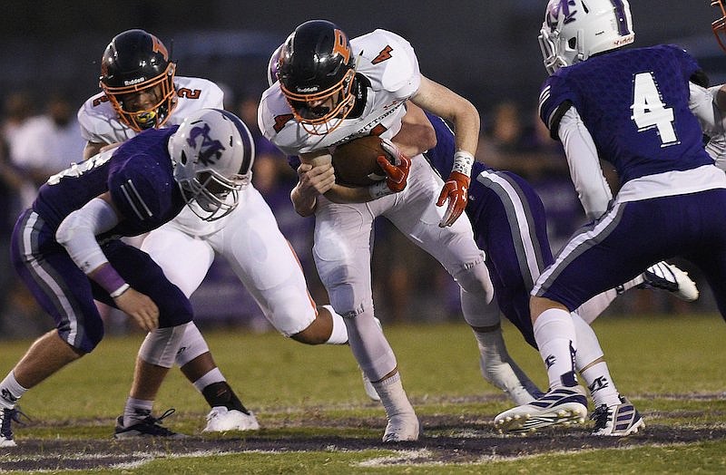 Staff Photo by Robin Rudd / South Pittsburg's Hunter Frame (4) drags a Warrior tackler as he gets yardage. The South Pittsburg Pirates visited the Marion County Warriors in a TSSAA rivalry game on September 13, 2019.