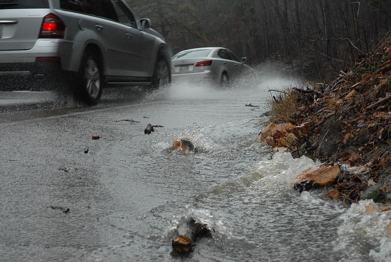 Staff file photo / Traffic up Signal Mountain Boulevard encounters streams of water across the roadway during heavy rains in this file photo. The town of Signal Mountain plans to double its stormwater fee to cover the costs of infrastructure repairs.