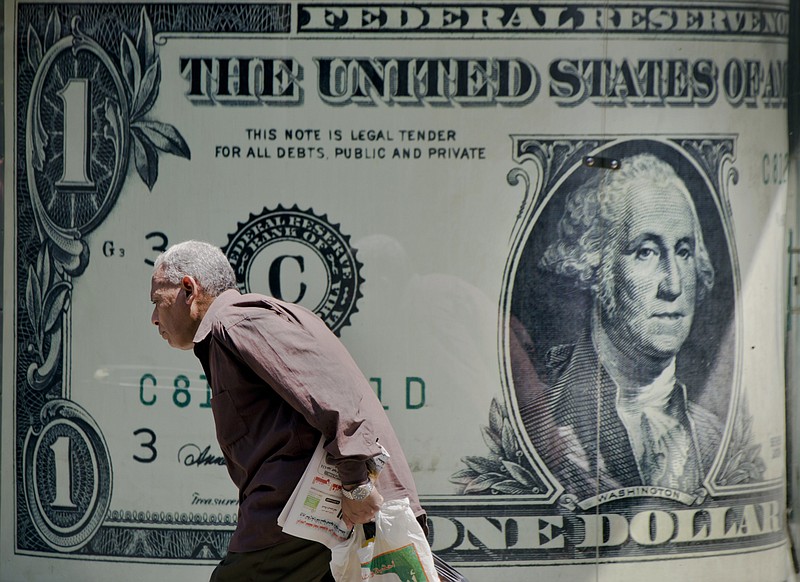 A man walks past a poster showing a US dollar outside an exchange office in Cairo, Egypt, in a Wednesday, Aug. 17, 2016 file photo.In 2019, before the coronavirus pandemic hit and the U.S. economy crashed, median household income was the highest ever on record, but the number of U.S. residents without health insurance also increased, the U.S. Census Bureau reported Tuesday, Sept. 15, 2020. AP Photo/Amr Nabil, File)