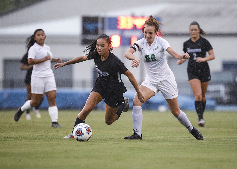 Staff photo by Troy Stolt / GPS soccer player Sydney Morris gets past East Hamilton midfielder Madison Buckner during Wednesday night's game at GPS. The host Bruisers won 3-1.