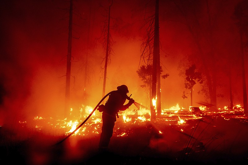 In this Sept. 11, 2020, file photo, firefighters monitor a controlled burn along Nacimiento-Fergusson Road to help contain the Dolan Fire near Big Sur, Calif. This year's fires have taxed the human, mechanical and financial resources of the nation's wildfire fighting forces to a degree that few past blazes did. And half of the fire season is yet to come. (AP Photo/Nic Coury,File)