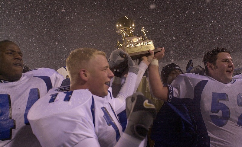 Staff photo / From left, Red Bank football players Fletcher Williams, Lucas Oakes and Tyler Rich walk toward their team's fans with the TSSAA Class 5A trophy after the Lions' 27-7 win against Riverdale at Middle Tennessee State University to win the state title on Dec. 2, 2000.