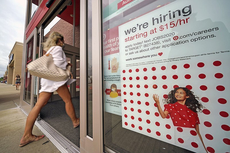 FILE - In this Sept. 2, 2020, file photo, a help wanted sign hangs on the door of a Target store in Uniontown, Pa. Hundreds of thousands of Americans likely applied for unemployment benefits last week, a high level of job insecurity that reflects economic damage from the coronavirus outbreak. Economists expect that 850,000 people sought jobless aid, down from 884,000 the week before, according to a survey by the data firm FactSet. (AP Photo/Gene J. Puskar, File)