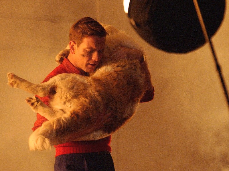 Actor Ewan McGregor (as young Edward Bloom) carries a St. Bernard puppy through a burning house in a scene from the Tim Burton film "Big Fish." / AP File Photo/Montgomery Advertiser/David Bundy