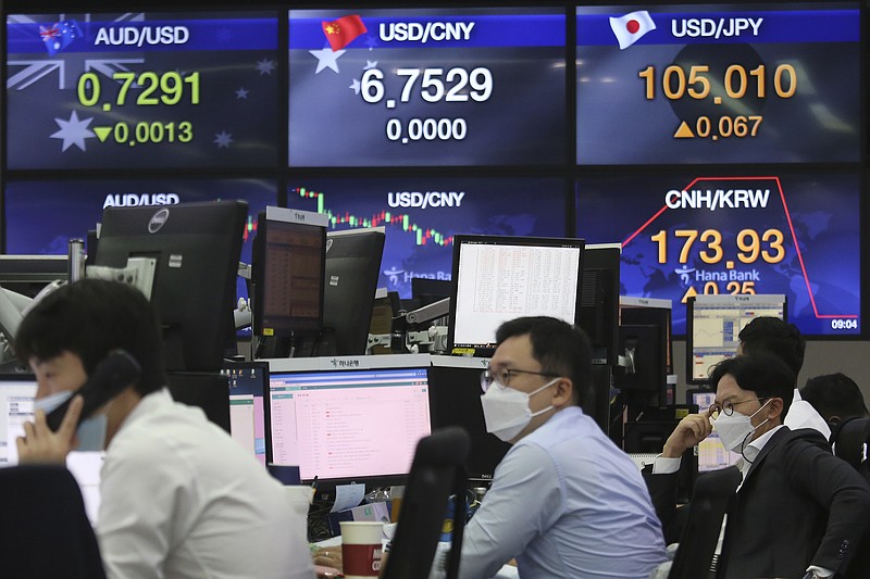 Currency traders work at the foreign exchange dealing room of the KEB Hana Bank headquarters in Seoul, South Korea, Thursday, Sept. 17, 2020. Asian stock markets declined Thursday after the U.S. Federal Reserve indicated its benchmark interest rate will stay close to zero at least through 2023 but announced no additional stimulus plans. (AP Photo/Ahn Young-joon)