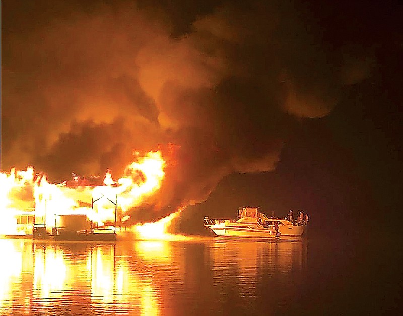Photo contributed by National Transportation and Safety Board / This photo from a witness shows evacuees aboard the two vessels prior to catching fire, drifting toward the end of Dock B at 1:09 a.m. CST. The NTSB credited J. Lindsey for the photo.