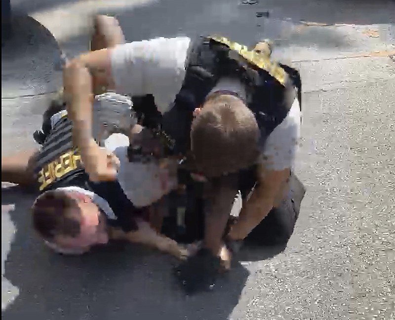 In this screen grab from video shot by Juanita Davis and provided by The Cochran Firm, a Clayton County, Ga., sheriff's deputy holds down Roderick Walker while another deputy punches him while on the ground, Friday, Sept. 11, 2020, following a traffic stop. (Juanita Davis/Courtesy of The Cochran Firm via AP)