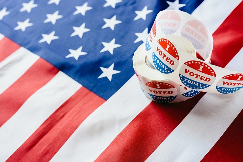 I vote today stickers roll, in US elections on American flag. voting tile vote tile ballot sticker tile / Getty Images
