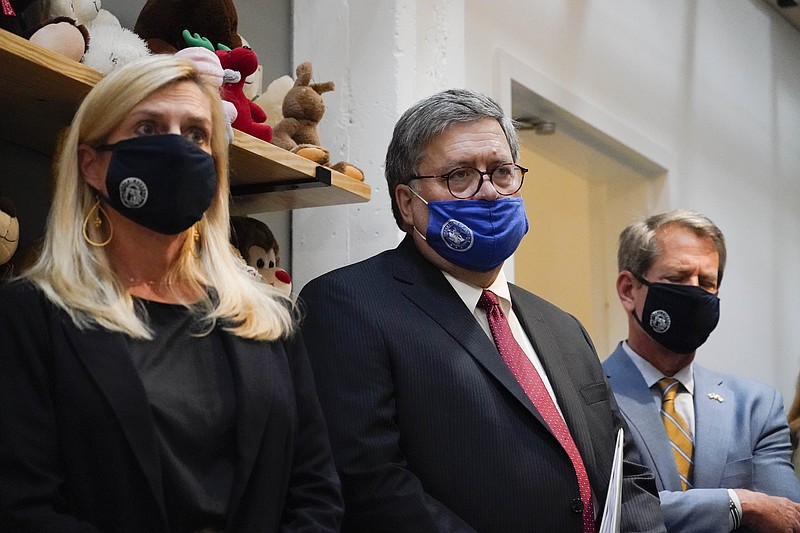 U.S. Attorney General William Barr, center, Georgia Gov. Brian Kemp, right and a Georgia Center for Child Advocacy staff member listen during a tour on Monday, Sept. 21, 2020, in Atlanta. (AP Photo/Brynn Anderson)