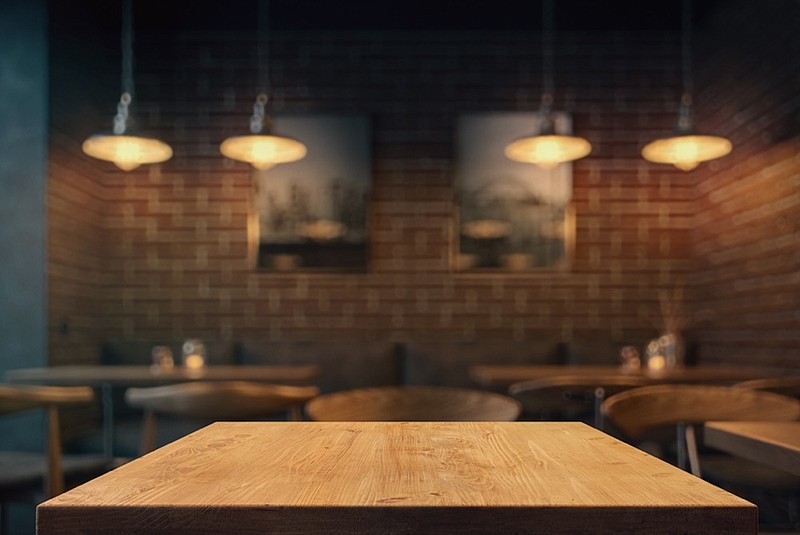 Empty tabletop in the coffee shop at night over defocused background with copy space restaurant tile / Getty Images
