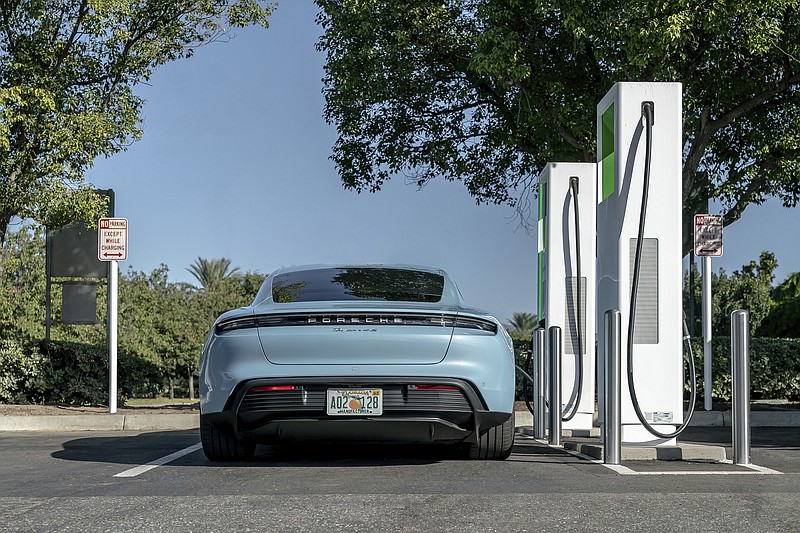 This photo provided by Porsche shows its first all-electric production car, the 2020 Taycan, charging up at a public charging station. Its official range according to the EPA is 203 miles on a single charge, but in Edmunds' testing the Taycan showed it's capable of going over 100 additional miles. (Courtesy of Porsche Cars North America via AP)