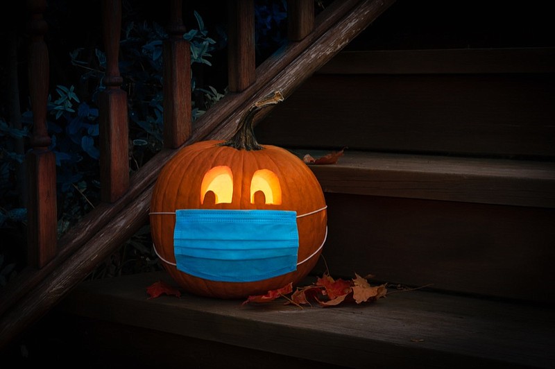 Lighted Halloween Pumpkin Jack o Lantern Wearing Covid PPE Mask On Steps halloween tile coronavirus tile / Getty Images
