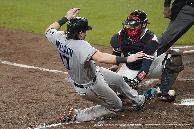 AP photo by John Bazemore / Chad Wallach scores for the Miami Marlins on a Jon Berti double as the ball gets away from Atlanta Braves catcher Travis d'Arnaud during the sixth inning Thursday night in Atlanta.