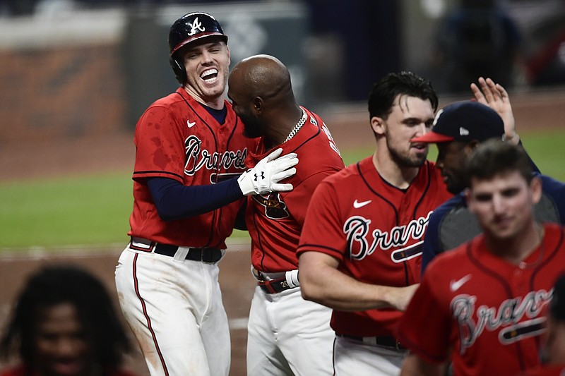 AP photo by John Amis / Atlanta Braves first baseman Freddie Freeman, left, celebrates with teammates after hitting the winning two-run home during the 11th inning of Friday night's 8-7 victory against the Boston Red Sox.