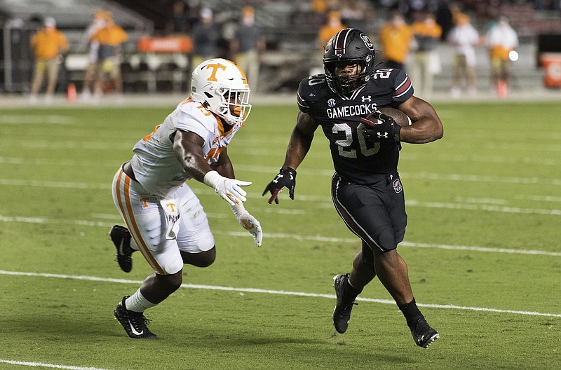 AP photo by Sean Rayford / South Carolina running back Kevin Harris heads to the end zone for a touchdown by slipping past Tennessee linebacker Deandre Johnson during the first half of Saturday night's game in Columbia, S.C.