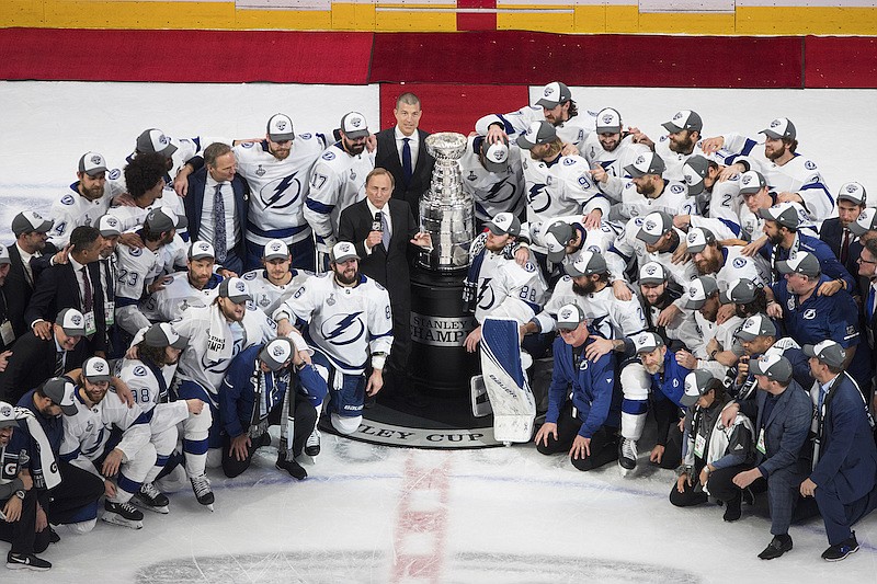 Tampa Bay Lightning players surround NHL Commissioner Gary Bettman as they celebrate after defeating the Dallas Stars to win the Stanley Cup in Edmonton, Alberta, on Monday, Sept. 28, 2020. (Jason Franson/The Canadian Press via AP)