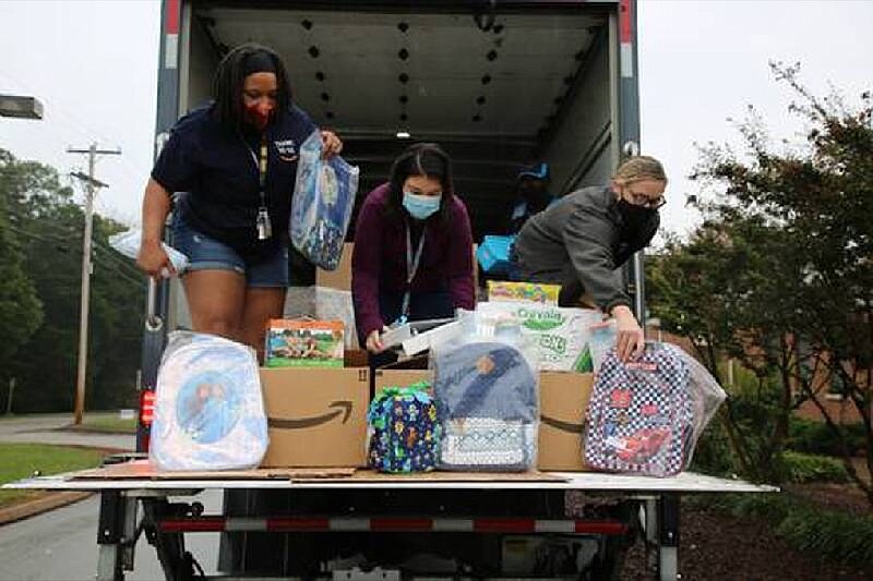 Courtesy photo by Hamilton County Schools / Amazon employees Monique Geter, Ashley Webb-Grabe, and Jessica Bramlett (left to right) unpack the truck filled with school supplies at Bess T. Shepherd Elementary School.