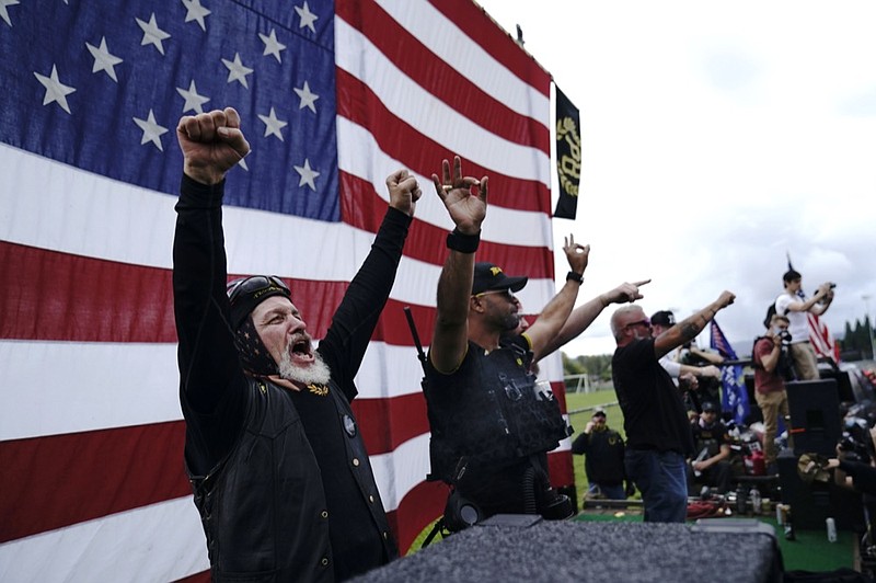 FILE - Members of the Proud Boys cheer on stage as they and other right-wing demonstrators rally, Saturday, Sept. 26, 2020, in Portland, Ore. President Donald Trump didn't condemn white supremacist groups and their role in violence in some American cities this summer. Instead, he said the violence is a "left-wing" problem and he told one far-right extremist group to "stand back and stand by." His comments Tuesday night were in response to debate moderator Chris Wallace asking if he would condemn white supremacists and militia groups. Trump's exchange with Democrat Joe Biden left the extremist group Proud Boys celebrating what some of its members saw as tacit approval. (AP Photo/John Locher)


