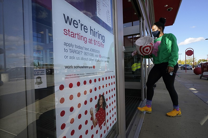 FILE - In this Sept. 30, 2020, file photo, a passerby walks past a hiring sign while entering a Target store in Westwood, Mass. The U.S. unemployment rate dropped to 7.9% in September, but hiring is slowing and many Americans have given up looking for work, the government said Friday, Oct. 2, in the final jobs report before the voters decide whether to give President Donald Trump another term. (AP Photo/Steven Senne, File)