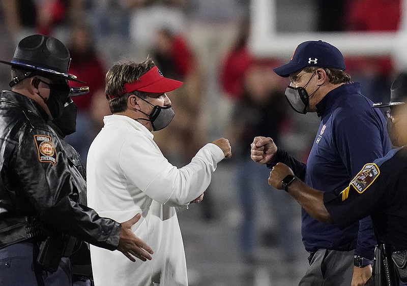 AP photo by Brynn Anderson / Georgia coach Kirby Smart, left, and Auburn counterpart Gus Malzahn bump fists after Saturday night's game, which the Bulldogs hosted and won 27-6 as Smart improved to 5-1 in the Deep South's Oldest Rivalry.
