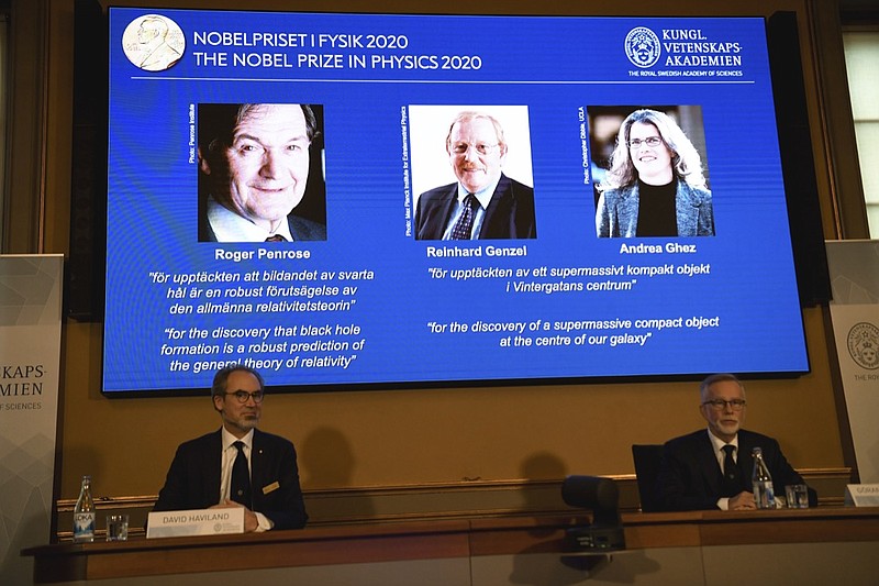 David Haviland, member of the Nobel Committee for Physics, left, and Goran K. Hansson, Secretary General of the Academy of Sciences, announce the winners of the 2020 Nobel Prize in Physics during a news conference at the Royal Swedish Academy of Sciences, in Stockholm, Sweden, Tuesday Oct. 6, 2020. The three winners on the screen from left, Roger Penrose, Reinhard Genzel and Andrea Ghez have won this year's Nobel Prize in physics for black hole discoveries. (Fredrik Sandberg/TT via AP)