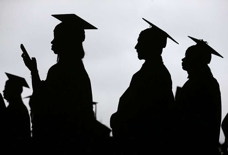 FILE - In this May 17, 2018, file photo, new graduates line up before the start of the Bergen Community College commencement at MetLife Stadium in East Rutherford, N.J. Many new college graduates are struggling to find work as their first student loan payments loom on the horizon. Fewer entry-level jobs are available during the pandemic, and unemployment benefits typically aren't accessible. (AP Photo/Seth Wenig, File)