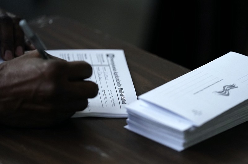 FILE - In this Sept. 29, 2020, file photo Philadelphia City Council President Darrell L. Clarke fills out an application for a mail-in ballot before voting at the opening of a satellite election office at Temple University's Liacouras Center in Philadelphia. Pennsylvania has seen a frenzy of election-related lawsuits as state officials prepare for some 3 million people, about half the expected turnout, to cast mail-in ballots. (AP Photo/Matt Slocum, File)


