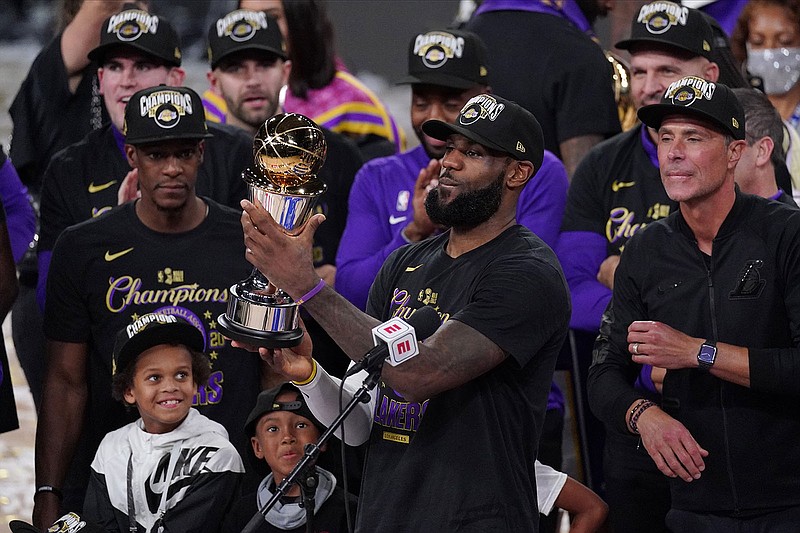 AP photo by Mark J. Terrill / Los Angeles Lakers star LeBron James holds the NBA Finals MVP trophy as he celebrates with his teammates after they beat the Miami Heat 106-93 in Game 6 of the NBA Finals on Sunday night in Lake Buena Vista, Fla.