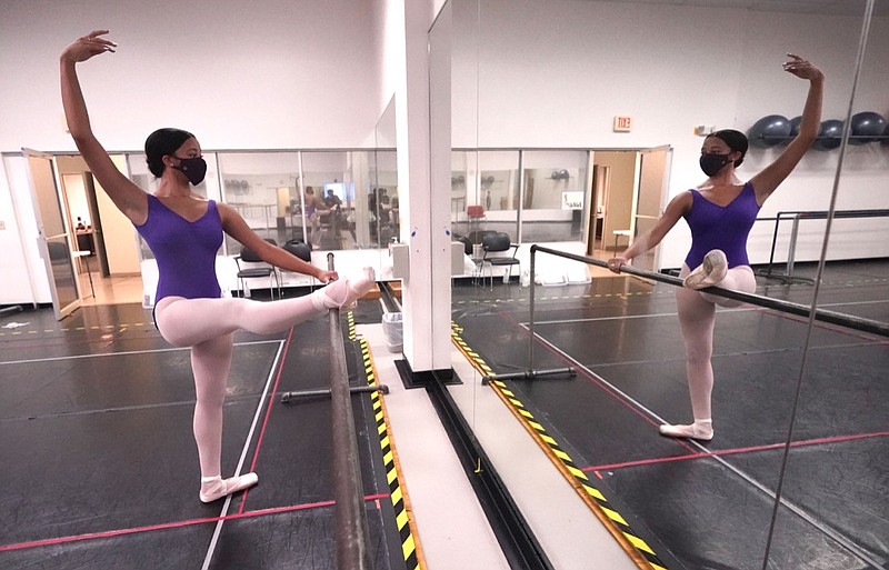 Ballet student Micah Sparrow stretches in a classroom at the Texas Ballet Theatre, Wednesday, Oct. 7, 2020, in Fort Worth, Texas. For many, it's not Christmas without the dance of Clara, Uncle Drosselmeyer, the Sugar Plum Fairy, the Mouse King and, of course, the Nutcracker Prince. But this year the coronavirus pandemic has canceled performances of "The Nutcracker" around the U.S. and Canada, eliminating a major and reliable source of revenue for dance companies already reeling financially following the essential shutdown of their industry. (AP Photo/LM Otero)