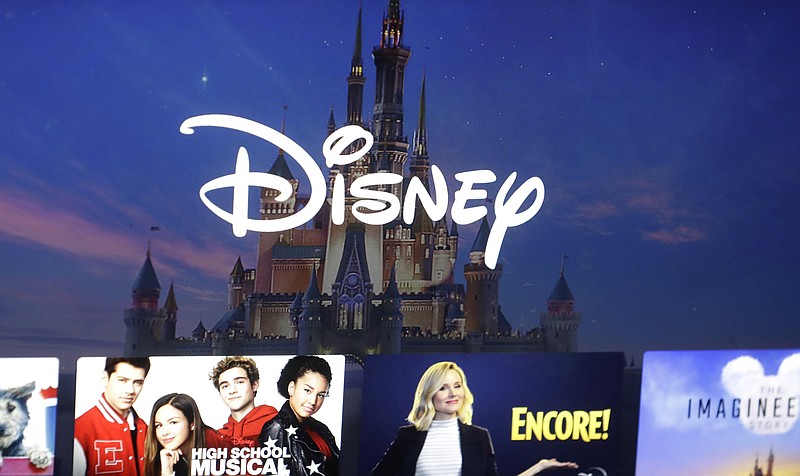 In this Nov. 13, 2019 file photo, a Disney logo forms part of a menu for the Disney Plus movie and entertainment streaming service on a computer screen in Walpole, Mass. Disney said Monday, Oct. 12, 2020 that it is reorganizing its business units to focus even more on streaming. The company said in August that its Disney Plus service has more than 60 million subscribers, and subscribers to its main combination of streaming services — Disney Plus, ESPN Plus and Hulu — top 100 million. It still plans to launch another international streaming service called Star. (AP Photo/Steven Senne, File)