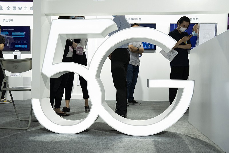 In this Sept. 17, 2020 file photo, visitors wearing mask to protect from the coronavirus walk past a 5G sign at the China Beijing International High Tech Expo in Beijing, China. A much-hyped network upgrade called "5G" means different things to different people. To industry proponents, it's the next huge innovation in wireless internet. To the U.S. government, it's the backbone technology of a future that America will wrestle with China to control. (AP Photo/Ng Han Guan, File)