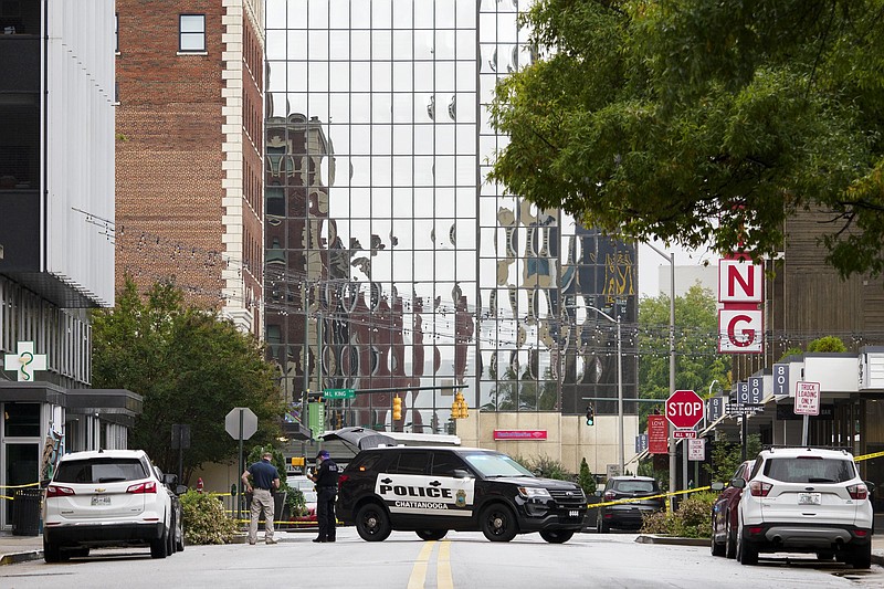 Staff photo by C.B. Schmelter / Police stand near a crime scene on Chestnut Street on Sunday, Oct. 11, 2020 in Chattanooga, Tenn.