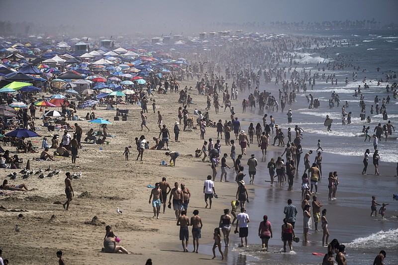 In this Saturday, Sept. 5, 2020 file photo, people crowd the beach in Huntington Beach, Calif., as the state swelters under a heat wave. On Wednesday, Oct. 14, 2020, the U.S. National Oceanic and Atmospheric Administration said the Earth reached a record hot September, saying that there's nearly a two-to-one chance that 2020 will end up as the globe's hottest year on record. (AP Photo/Jae C. Hong)