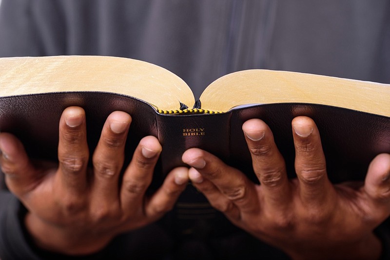 A close up view of a man hands holding the Holy Bible, Worship Concept pastor tile church tile faith religion / Getty Images
