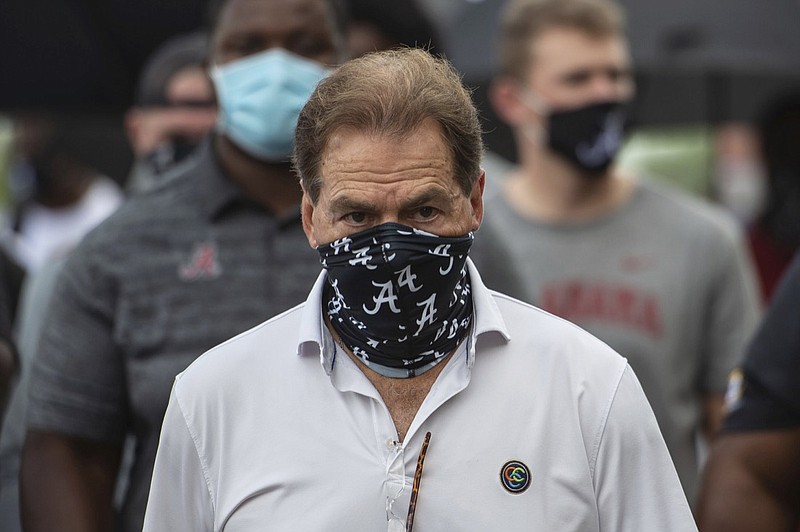 FILE - In this Aug. 31, 2020, file photo, Alabama head football coach Nick Saban leads his team as they march on campus, supporting the Black Lives Matter movement, in Tuscaloosa, Ala. The mid-week news that Alabama coach Nick Saban tested positive for COVID-19 added a challenging backdrop for the season's first Top 5 matchup. Saban figures to be communicating his marching orders and input from home while offensive coordinator Steve Sarkisian is manning the show within the football building. (AP Photo/Vasha Hunt, File)