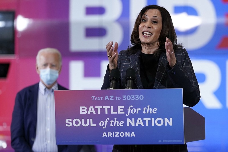 In this Oct. 8, 2020, photo, Democratic vice presidential candidate Sen. Kamala Harris, D-Calif., speaks at Carpenters Local Union 1912 in Phoenix, as Democratic presidential candidate former vice president Joe Biden listens. Biden's presidential campaign says Harris will suspend in-person events until Oct. 19, after two people associated with the campaign tested positive for coronavirus. (AP Photo/Carolyn Kaster)