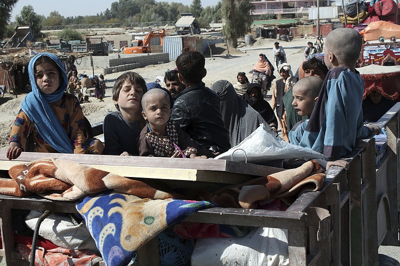 Afghan families leave their houses after fighting between the Afghan military and Taliban insurgents in Helmand province, southern of Afghanistan, Tuesday, Oct. 13, 2020. (AP Photo/Abdul Khaliq)