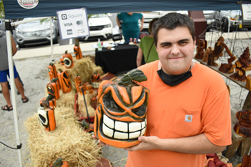 Staff photo by Matt Hamilton / Jake Bray and a chainsaw-carved pumpkin he made