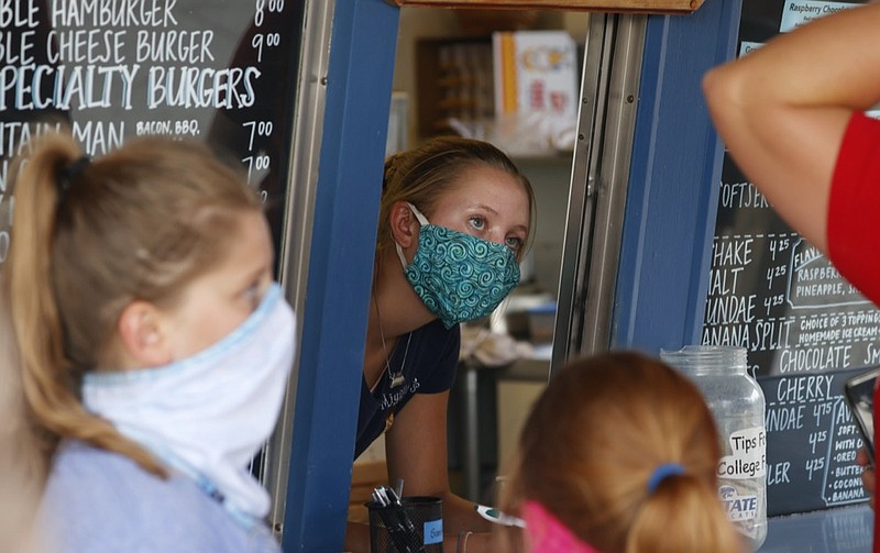 FILE - In this Aug. 4, 2020 file photo, a staffer wears a mask while taking orders at a small restaurant in Grand Lake, Colo., amid the coronavirus pandemic. The coronavirus pandemic has put millions of Americans out of work. But many of those still working are fearful, distressed and stretched thin, according to a new poll by The Associated Press-NORC Center for Public Affairs Research. (AP Photo/David Zalubowski, File)


