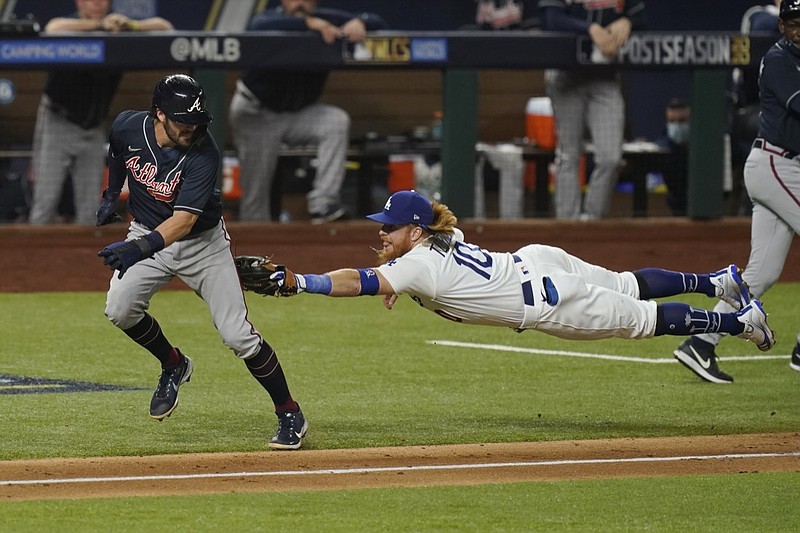 Los Angeles Dodgers third baseman Justin Turner tags Atlanta Braves' Dansby Swanson in a run down during the fourth inning in Game 7 of a baseball National League Championship Series Sunday, Oct. 18, 2020, in Arlington, Texas. (AP Photo/Eric Gay)