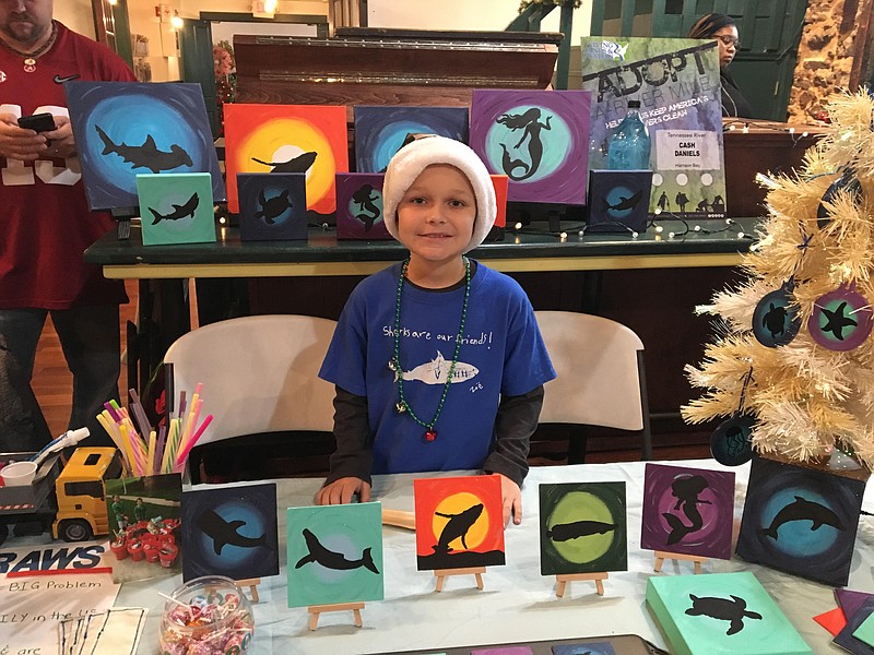 Photo by Erin Daniels / Cash Daniels poses with original art he created and sells through his business, The Conservation Kid, to help raise money for anti-whaling organizations.