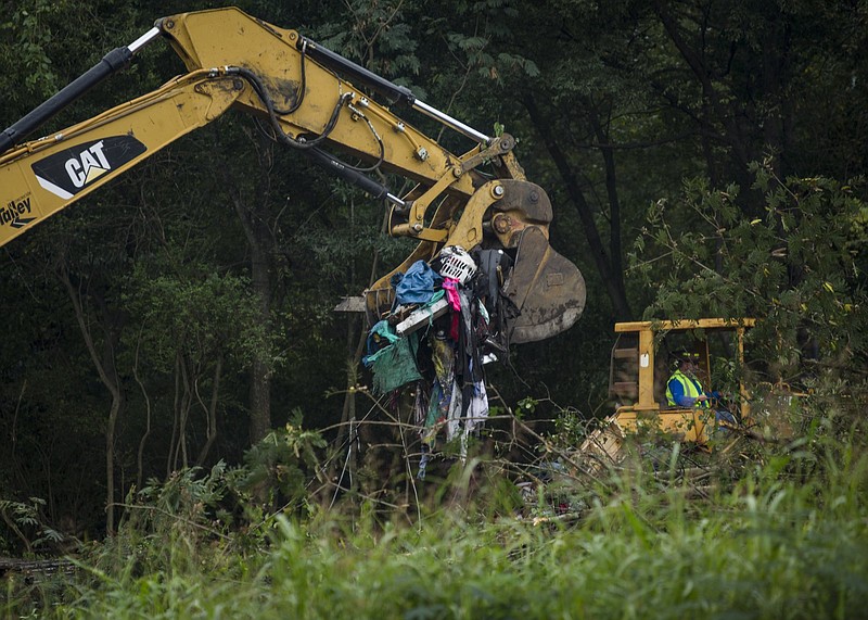 Staff photo by Troy Stolt / An excavator drops various items of clothing, tents, and mattresses belonging to residents of a homeless encampment located off of Workman Road on Tuesday, Sept. 29, 2020 in Chattanooga, Tenn.