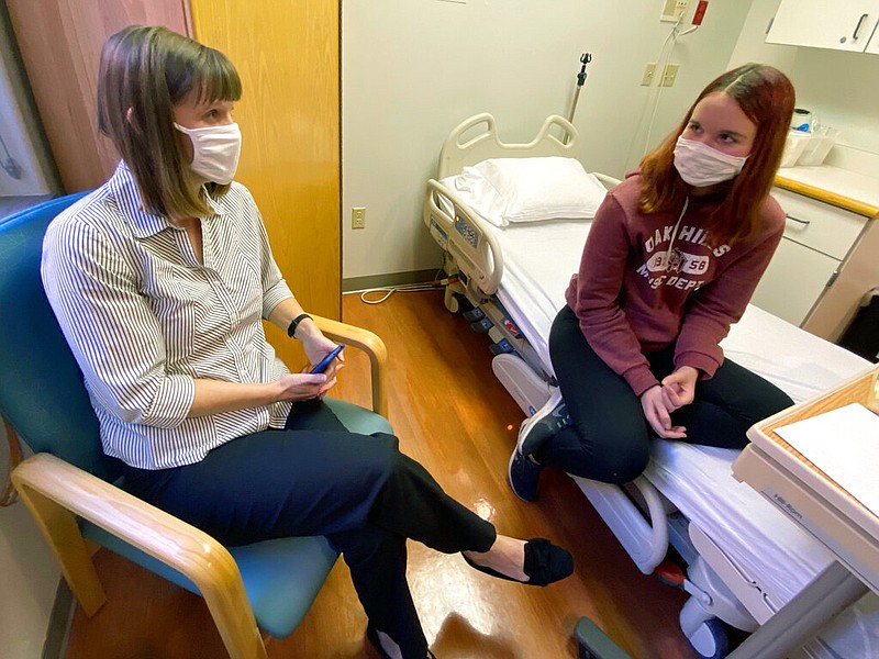 In this photo provided by Cincinnati Children's Hospital Medical Center, Katelyn Evans, right, a vaccine trial participant, speaks to her mother Laurie Evans ahead of receiving an injection in Pfizer's COVID-19 vaccine trial at Cincinnati Children's Hospital Medical Center on Wednesday, Oct. 14, 2020. (Cincinnati Children's Hospital Medical Center via)