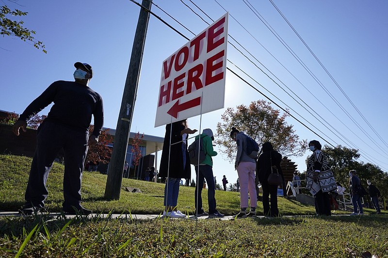 Early voters wait to cast their ballots at the South Regional Library polling location in Durham, N.C., Thursday, Oct. 15, 2020. (AP Photo/Gerry Broome)