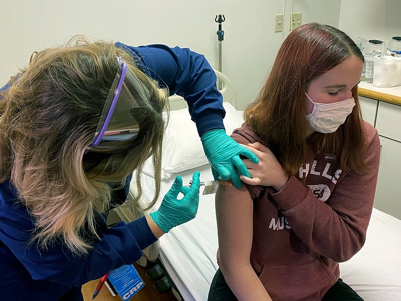 In this photo provided by Cincinnati Children's Hospital Medical Center, clinical research coordinator Tammy Lewis-McCauley administers an injection to Katelyn Evans, a trial participant, as part of the hospital's clinical trial of Pfizer's COVID-19 vaccine at Cincinnati Children's Hospital Medical Center on Wednesday, Oct. 14, 2020. (Cincinnati Children's Hospital Medical Center via AP)