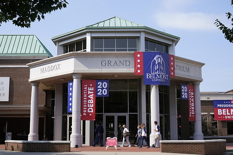 People walk outside the Curb Event Center at Belmont University as preparations take place for the second Presidential debate, Tuesday, Oct. 20, 2020, in Nashville, Tenn. President Donald Trump and Democratic presidential candidate, former Vice President Joe Biden are scheduled to debate Thursday, Oct. 22. (AP Photo/Patrick Semansky)